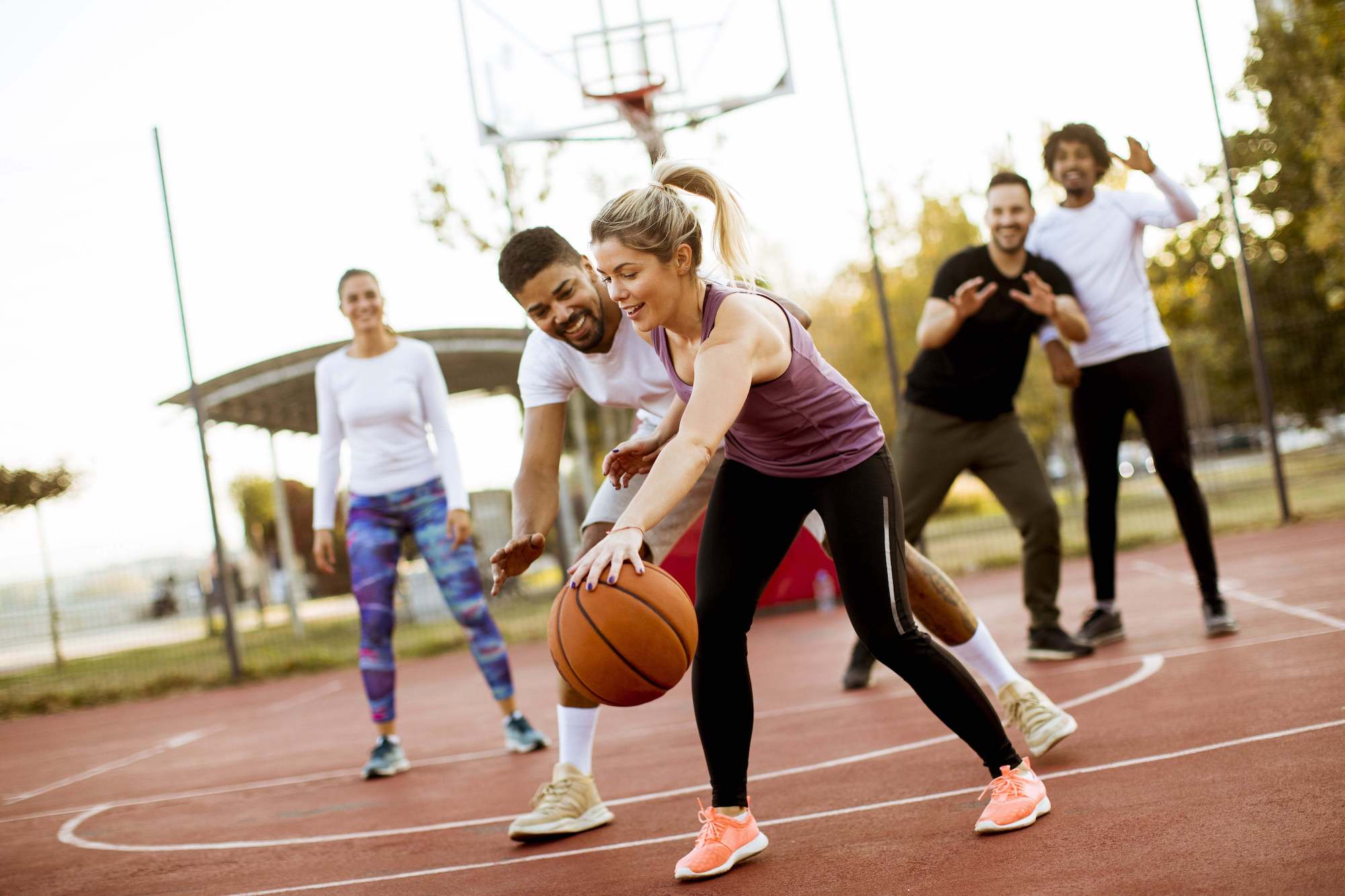 group of friends playing basketball outdoors